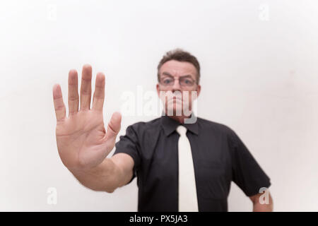 Signal de la main arrêter avec sérieux et rigoureux de l'homme strict en tissu noir et cravate blanche sur fond blanc Banque D'Images