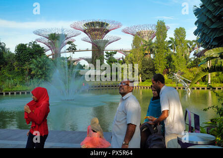 Par un étang à Gardens by the Bay à Singapour, les touristes étrangers, admirer le paysage en arrière-plan l'emblématique Super Tress Banque D'Images