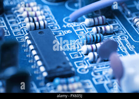 Microchip, condensateurs, résistances sur un ordinateur bleu bord de près. Contexte industriel. Banque D'Images