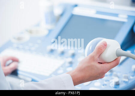 Jeune femme médecin mains près de la préparation pour un appareil à ultrasons scan. Banque D'Images