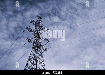 Ligne de transmission à haute tension. Contexte industriel avec une haute tension tower sur le fond bleu du ciel. Gros plan du tour de haute tension Banque D'Images