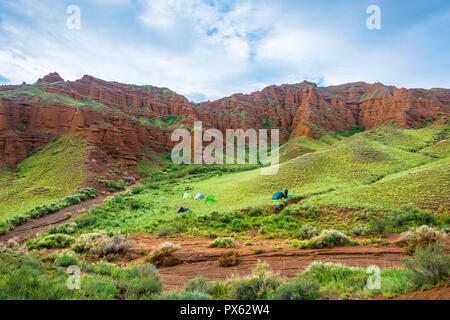 Un petit groupe de touristes dans les îles éoliennes sur les montagnes d'une journée ensoleillée, au Kirghizistan. Banque D'Images
