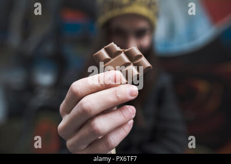 Close up on a woman's hands holding a mordu morceau de barre de chocolat Banque D'Images