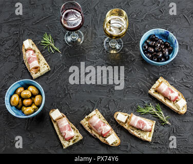 Vin apéritif cadre. Brushetta avec vin. Variété de petits sandwiches au bacon jambon, fromage parmesan, basilic frais et crème balsamique servi Banque D'Images