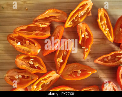 Shot de Naga Morich orange poivrons sur une planche à découper Banque D'Images