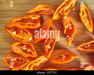 Shot de Naga Morich orange poivrons sur une planche à découper Banque D'Images