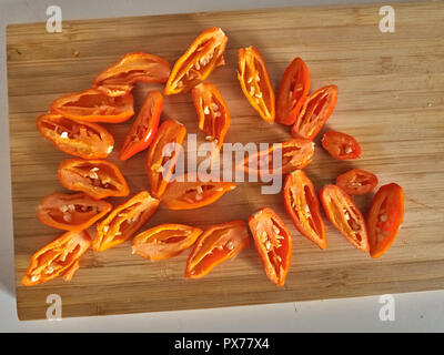 Shot de Naga Morich orange poivrons sur une planche à découper Banque D'Images