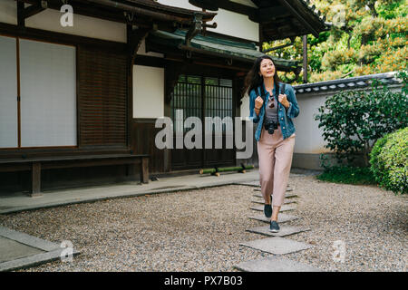 Photographe asiatique élégant juste fini de visiter le temple et sortir avec joie. Voyageant à la visite de Kyoto au Japon. Les touristes à la recherche du soleil en t Banque D'Images