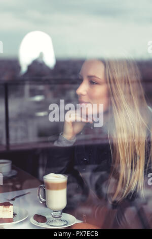 Portrait d'une dame avec une tasse de Latte assis dans le café, profiter de délicieux petit-déjeuner agréable, calme et détente concept Banque D'Images