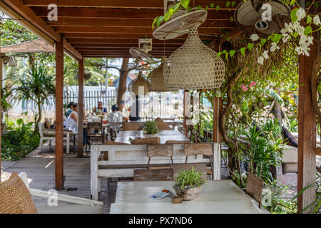 Table en bois blanc et des sièges avec des coussins à une zone ouverte café sur le bord d'une rizière, l'île de Bali, Indonésie Banque D'Images