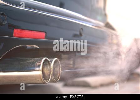 Close up of smoky les tuyaux d'échappement double à partir d'une voiture diesel. Banque D'Images