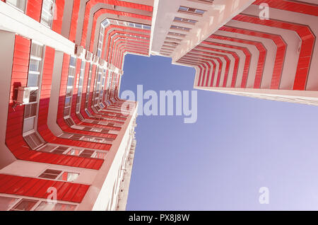 Vue d'un immeuble résidentiel à partir de la base. Maison blanche avec des balcons en rouge une chaude journée ensoleillée Banque D'Images