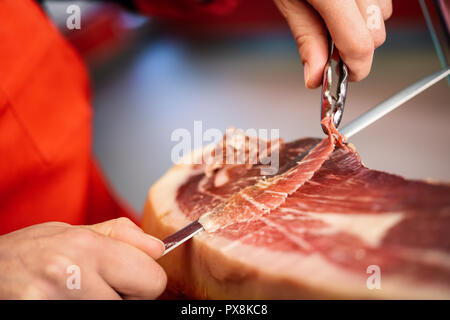 Close-up of professional cutter tranches à partir d'un ensemble de Sculpture en os de jambon serrano Banque D'Images