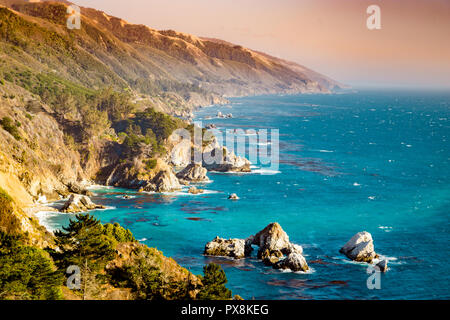 Vue panoramique sur la côte sauvage de Big Sur avec montagnes Santa Lucia le long de la route 1 célèbre illuminée en belle lumière du soir à soleils d'or Banque D'Images