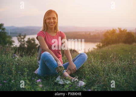 Belle femme au repos touristique avec vue sur la rivière et la ville derrière elle. Banque D'Images