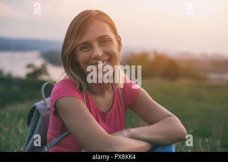 Belle femme au repos touristique avec vue sur la rivière et la ville derrière elle. Banque D'Images