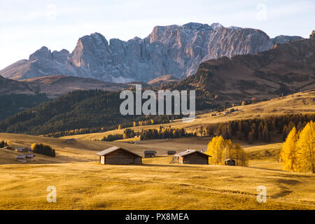 Belle vue sur la montagne chalets traditionnels en bois sur Scenic Alpe di Siusi célèbre Langkofel avec des pics de montagne dans l'arrière-plan dans la matinée d'or Banque D'Images