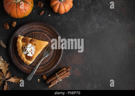 Tarte à la citrouille avec crème fouettée, cannelle et noix de pécan sur fond rustique, vue du dessus, copiez l'espace. L'automne fait maison pour pâtisserie grâce - morceau de Banque D'Images