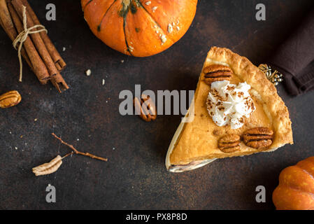 Tarte à la citrouille avec crème fouettée, cannelle et noix de pécan sur fond rustique, vue du dessus, copiez l'espace. L'automne fait maison pour pâtisserie grâce - morceau de Banque D'Images