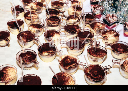 Beaucoup de tasses de panna cotta saupoudrée de chocolat en poudre Banque D'Images