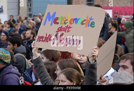 Rostock, Allemagne. 20 Oct, 2018. 20 octobre 2018, l'Allemagne, Rostock : 'Les droits de l'homme au lieu de la droite" est écrit sur un panneau qu'une femme est élevée pendant une manifestation contre un rassemblement de l'AfD. Une présence policière massive sépare les deux camps. Crédit : Bernd Wüstneck/dpa/Alamy Live News Banque D'Images