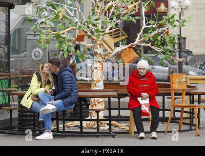 Kiev, Ukraine. 20 Oct, 2018. Un couple s'embrasser, alors qu'une femme plus âgée s'assoit à côté, dans le centre de Kiev, Ukraine, le 20 octobre 2018. Crédit : Serg Glovny/ZUMA/Alamy Fil Live News Banque D'Images