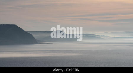 Charmouth, Dorset, UK. 20 octobre 2018. Météo France : Tôt le matin la brume se lève au-dessus de Cap d'or et les falaises le long de la Côte Jurassique près de Charmouth. Credit : Celia McMahon/Alamy Live News Banque D'Images