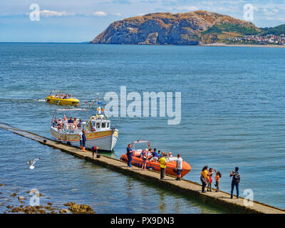 25 Juillet 2018 : Llandudno Conwy ; UK ; - les gens sur le Boardwalk et jetty ; monter et descendre de la mer Jay et un bateau à réaction ; pour les rides autour de la baie, avec.. Banque D'Images