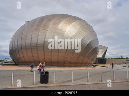 Famille marchant devant le cinéma IMAX sur le Glasgow Science Centre à Pacific Quay à Glasgow, Écosse, Royaume-Uni. Banque D'Images