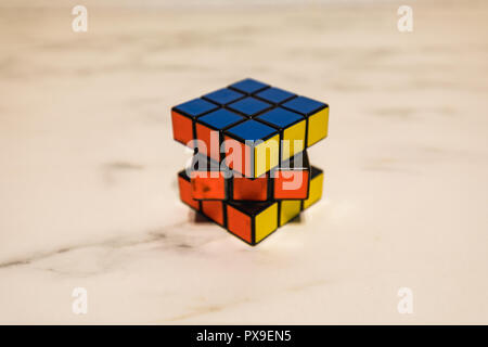 Rubik's Cube sur une plaque de marbre, montrant le bleu, le jaune et l'orange libre Banque D'Images