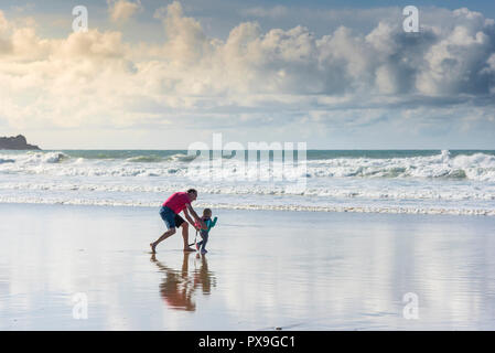 Un grand-père s'amusant avec sa petite-fille sur la plage de Fistral à Newquay en Cornouailles. Banque D'Images