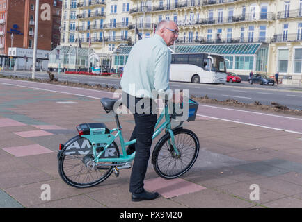 Middle aged man riding a louer / location de vélos loués à Brighton, East Sussex, Angleterre, Royaume-Uni. Banque D'Images