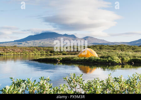 La tente jaune sur les rives d'un lac dans le parc national de Thingvellir, Islande. Banque D'Images