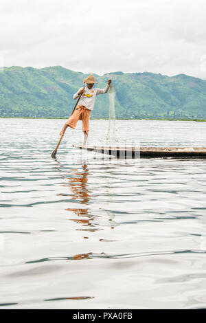 Billet : local jeune pêcheur birman portant shirt Manchester United, l'équilibrage et le bateau avec son pied dans le lac Inle, Birmanie, Myanmar, en Asie Banque D'Images