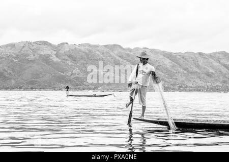 Billet : local jeune pêcheur birman portant shirt Manchester United, l'équilibrage et le bateau avec son pied dans le lac Inle, Birmanie, Myanmar, en Asie Banque D'Images