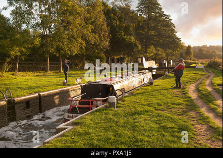 Conversation entre canal Barge à Catteshall verrou sur la rivière Wey, Godalming, au coucher du soleil sur une belle soirée d'été, avec une calme conversation tranquille Banque D'Images