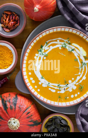 Crème de citrouille en soupière et assaisonné avec bol en céramique et les choux à la crème de cresson sur fond de bois Banque D'Images