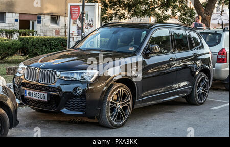 BMW X5 est garée dans le parking de la ville. Banque D'Images