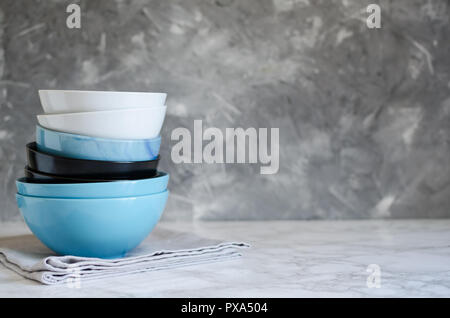 Pile de bols de céramique sur table de marbre contre mur gris minable avec place pour le texte. Vaisselle en céramique de table. Copier l'espace. Banque D'Images