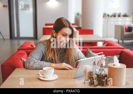 Portrait de jeune fille arménienne surpris dans cafe en utilisant comprimé. Banque D'Images