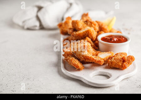 Poulet frit avec de la sauce tomate sur un tableau blanc. Banque D'Images