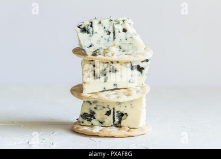 Portions de Fromage au Roquefort sur des craquelins isolé sur fond blanc avec selective focus Banque D'Images
