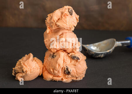 Boules de Glace empilée sur tableau noir avec en arrière-plan flou artistique scoop icecream - saveur rhum et au raisin Banque D'Images