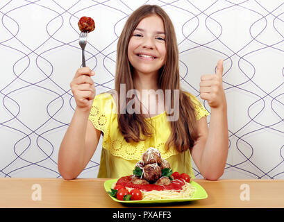 Beautiful happy girl avec des spaghetti et boulettes de viande et thumb up Banque D'Images