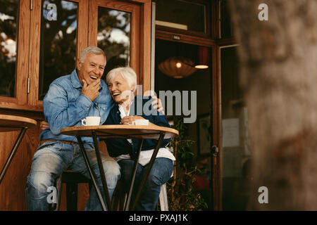 Senior couple in love sitting in cafe parler et avoir du plaisir. Bonne retraite couple relaxing at coffee shop. Banque D'Images