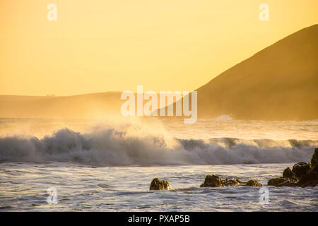 Coucher du soleil doré sur la côte du Pembrokeshire, dans le sud du Pays de Galles, UK.éclaboussures des vagues et brise du soir, falaises et brume en arrière-plan.paysage pittoresque Uk.Magic Banque D'Images