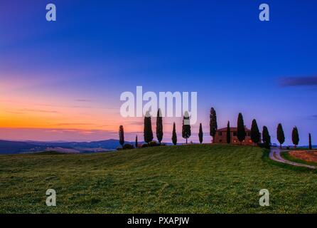 Toscane, Italie - 6 juillet 2018 : cyprès et prairie avec maison typique de Toscane, Val d'Orcia, Italie - Toscane Banque D'Images