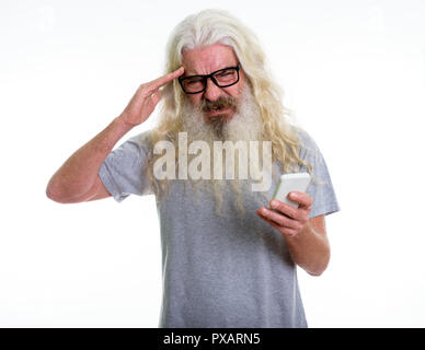 Studio shot of senior homme barbu holding mobile phone while hav Banque D'Images