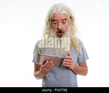 Studio shot of senior homme barbu using digital tablet alors que loo Banque D'Images