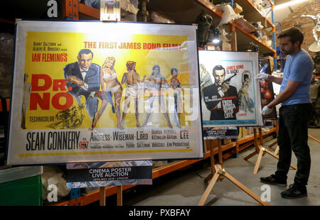 À l'embargo Lundi 22 octobre 0001 Soutenir l'employé du magasin Matt Story ajuste une affiche pour le film de James Bond 1963 From Russia with Love sur l'écran à côté d'une affiche pour le film 1962 Dr No lors d'un aperçu de la prochaine vente aux enchères d'affiches de cinéma à la prop Store siège social près de Rickmansworth. Banque D'Images